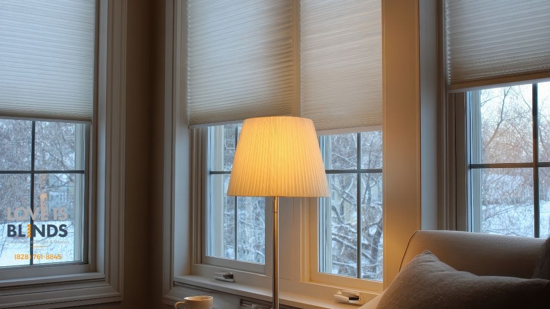 Cozy room with three windows.  A lit lampshade stands before the middle window. Snow visible outside.