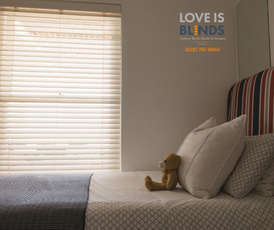 Bedroom scene with sunlight through blinds, a bed with pillows, and a teddy bear.
