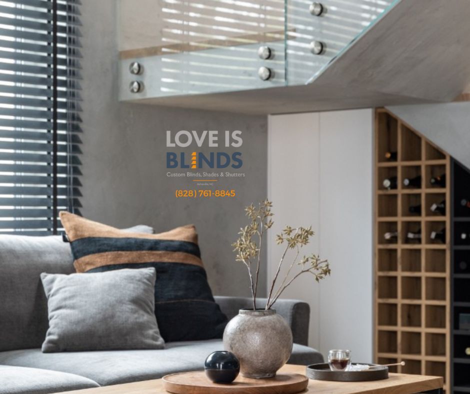 Cozy living room with sofa, blinds, and wine rack; advertisement for Love Is Blinds.