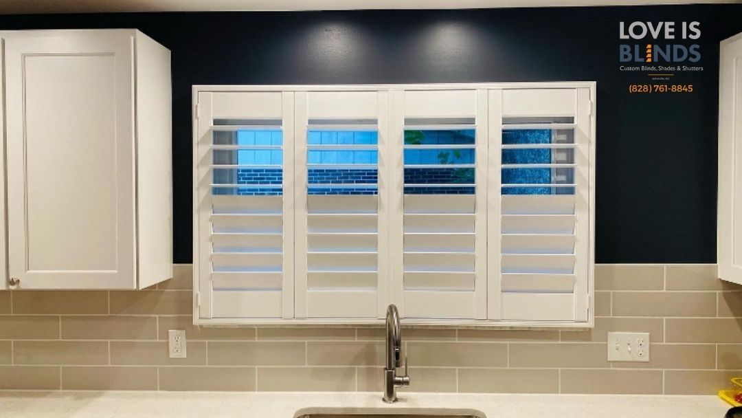 White kitchen window with shutters, under cabinet lights, and sink. 