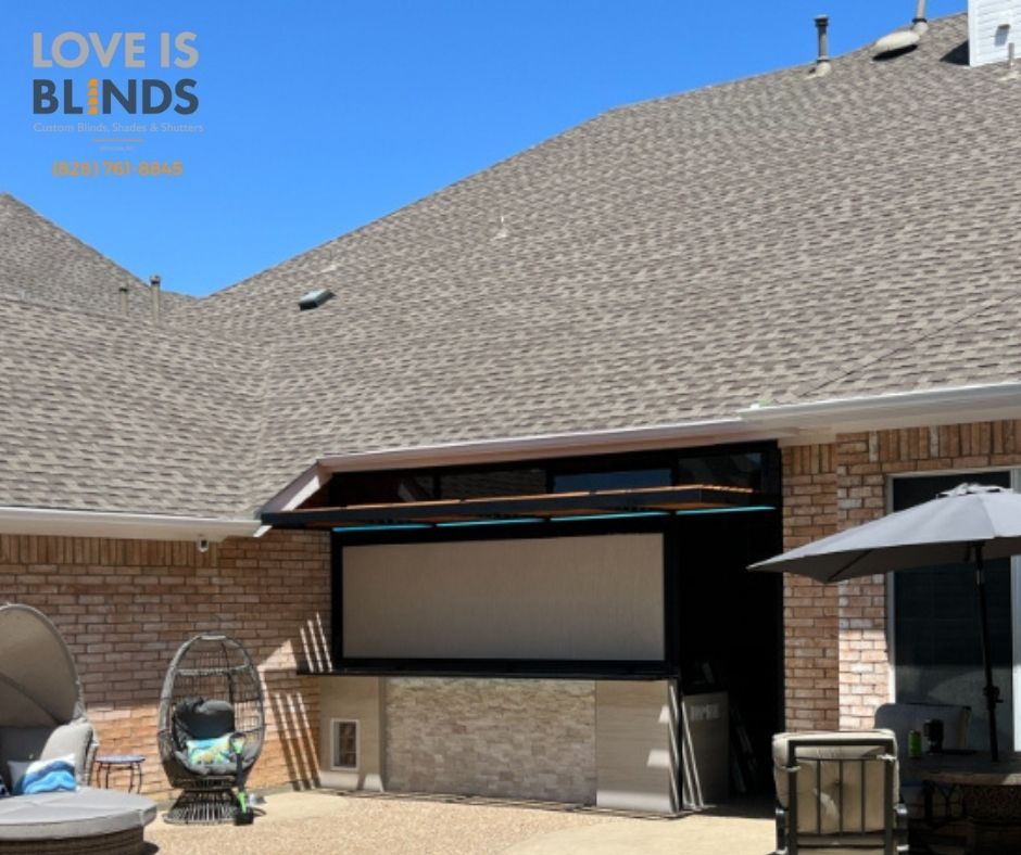Outdoor entertainment setup: retractable screen, patio, seating, brick building, sunny day.