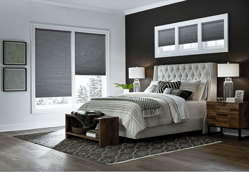 A bedroom with a bed , nightstand , and window shades. Love is Blinds Arizona (844) 936-2446