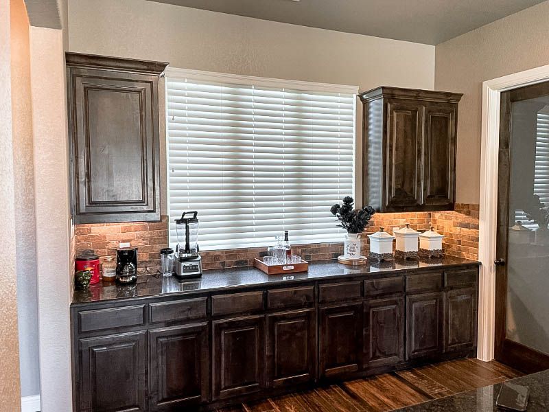 A kitchen with a lot of cabinets and a window. Love is Blinds Arizona (844) 936-2446