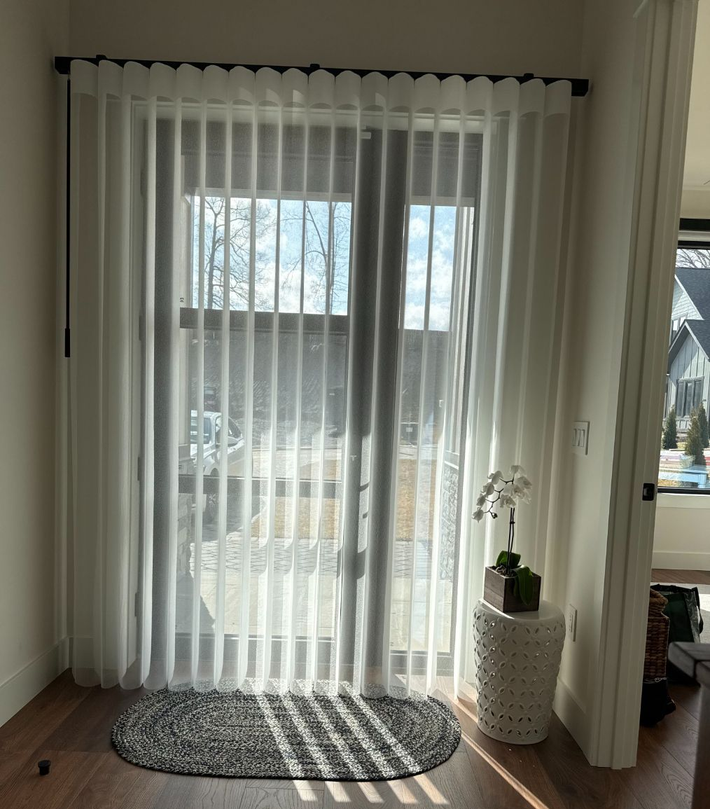 Bright living room with Norman SmarrtDrapes, sunlight on hardwood floor, and a small rug by a window.