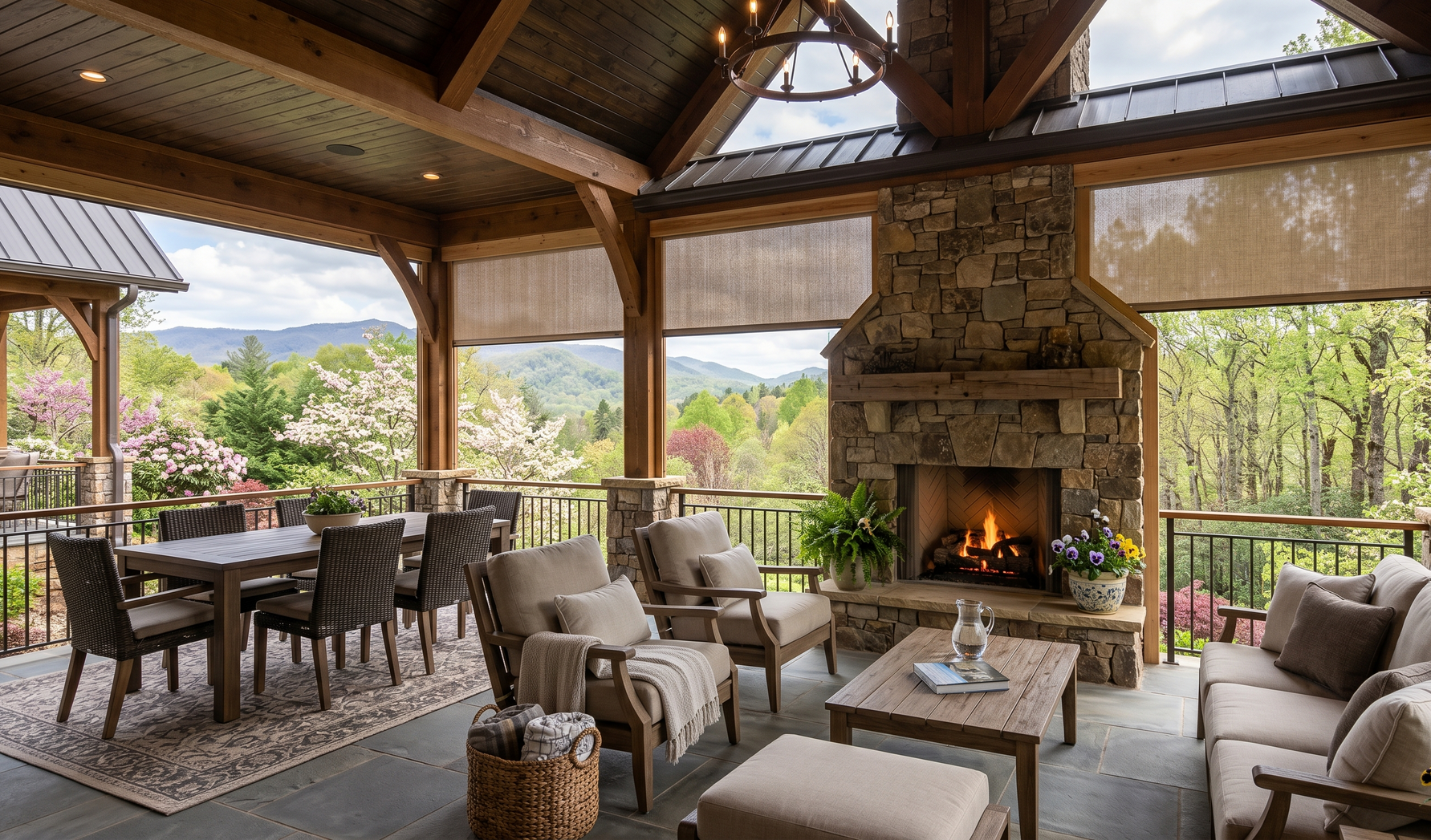 Covered outdoor living room with stone fireplace, exterior patio shades, and open views of a green mountain landscape