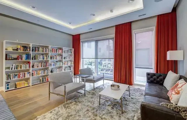A living room with a couch , chairs , coffee table and bookshelves. Love is Blinds North Carolina