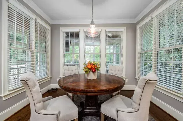 A dining room with a table and chairs and a chandelier. Love is Blinds North Carolina