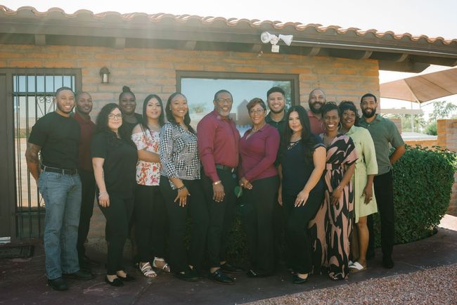 A group of URH staff are posing for a picture in front of a building.