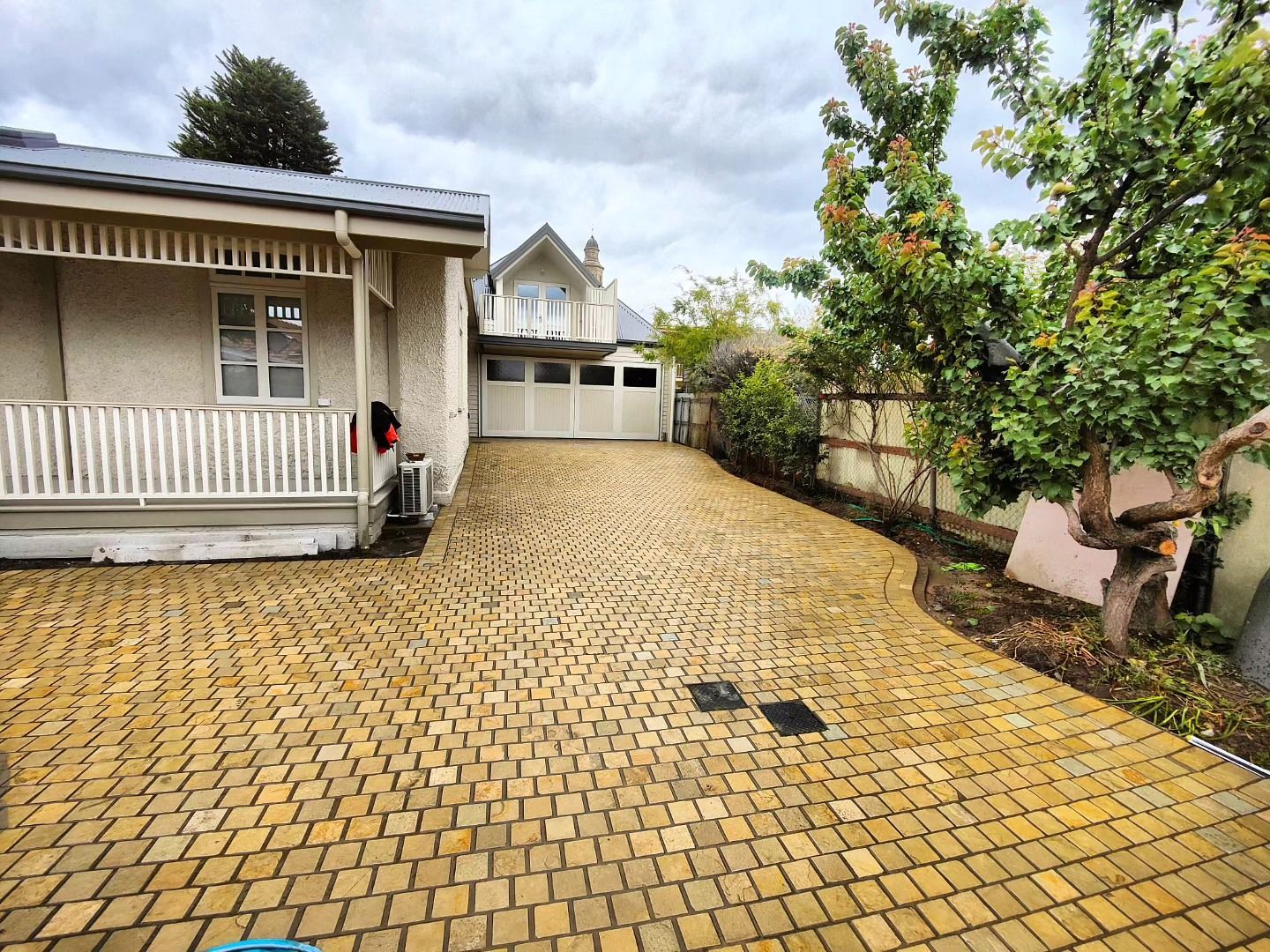 A yellow brick driveway leading to a white house