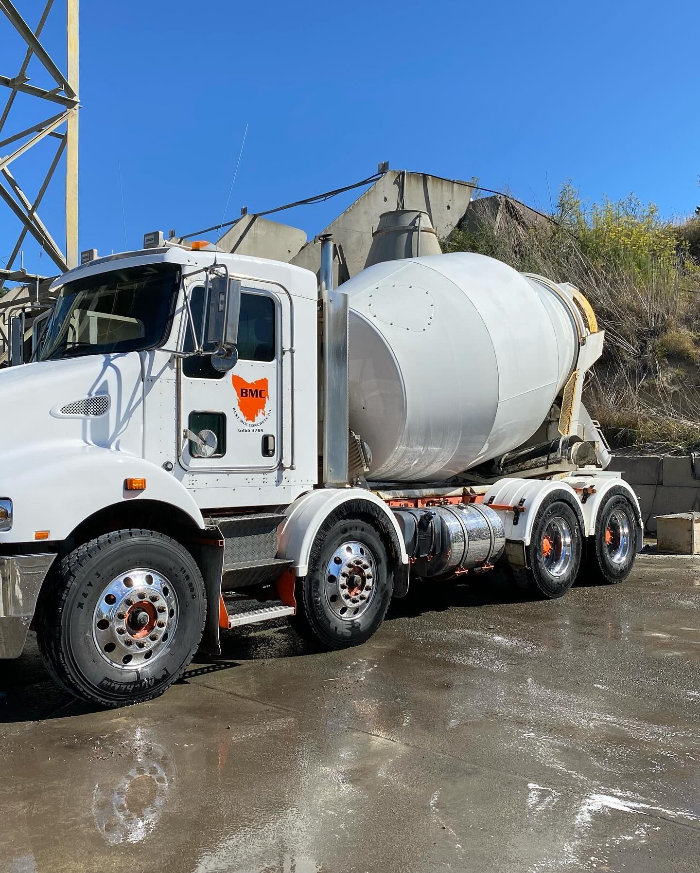 A man is pouring concrete into a form with a shovel.
