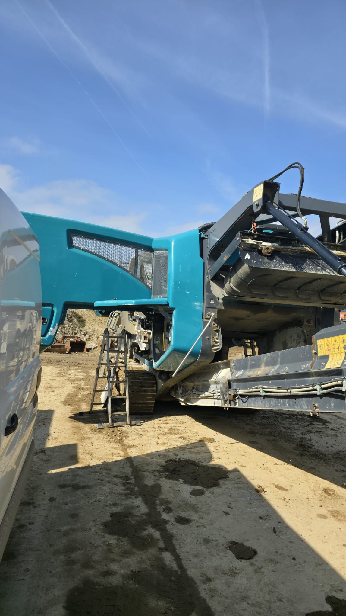 A woman is sitting at a desk with a laptop and smiling.