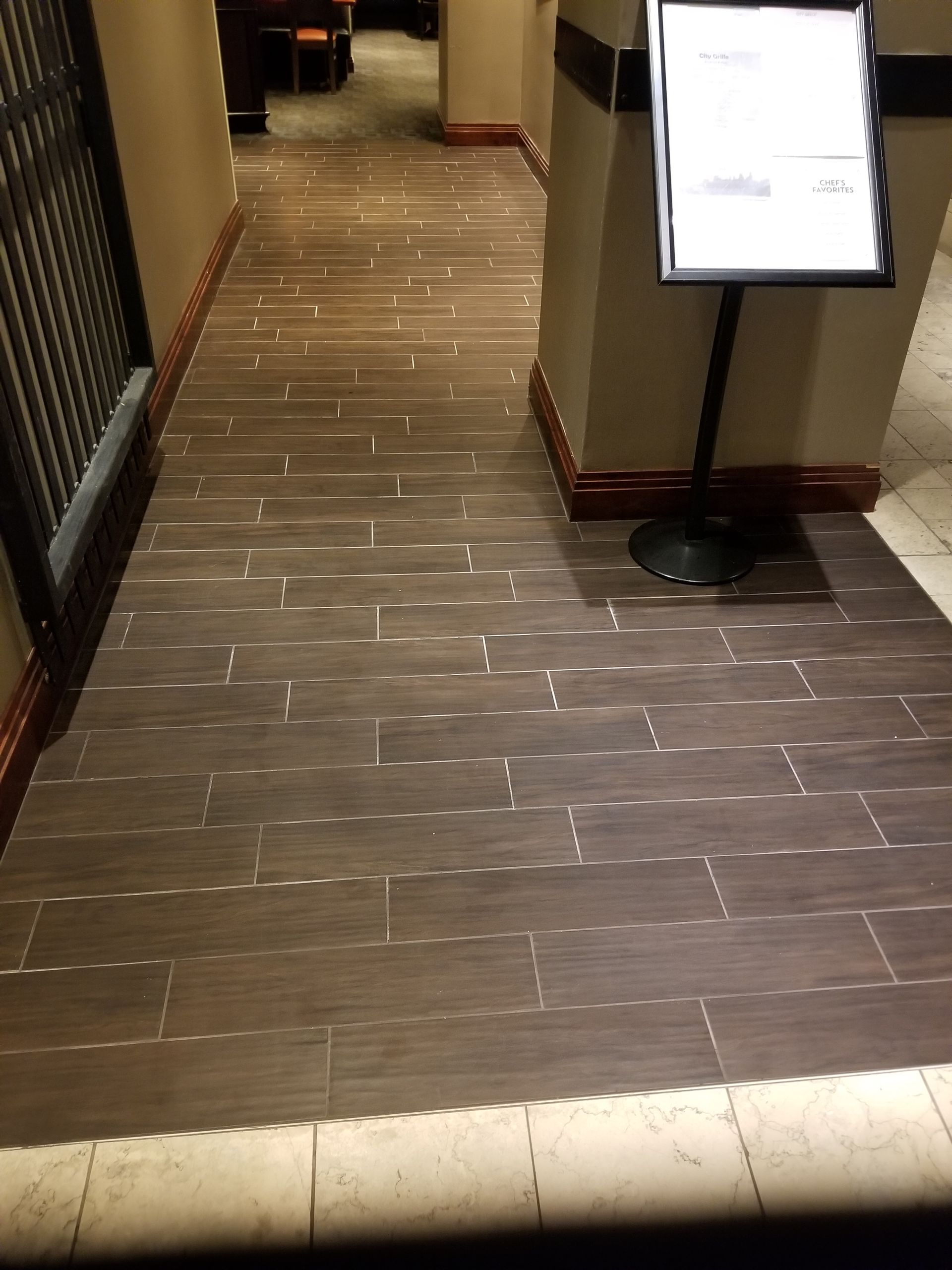 A hallway with a sign on the floor and a sign on the wall.