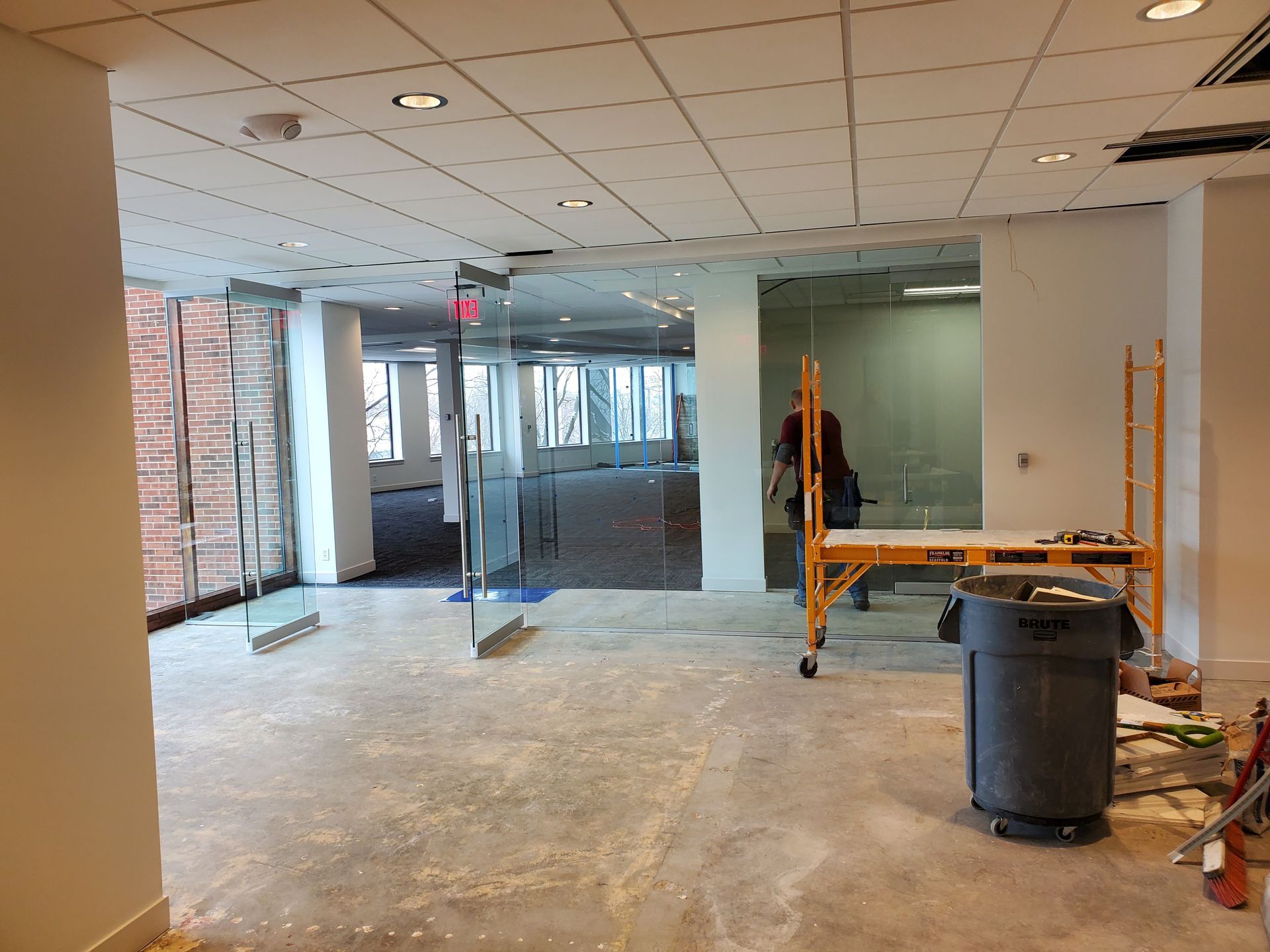 An empty room with a trash can in the middle of it.