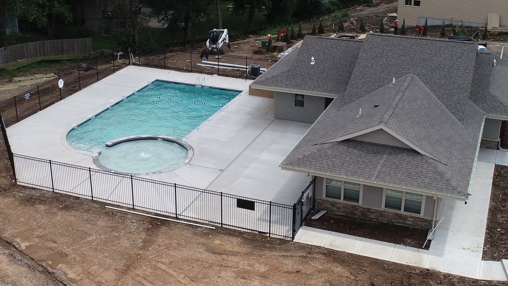 An aerial view of a house with a large swimming pool