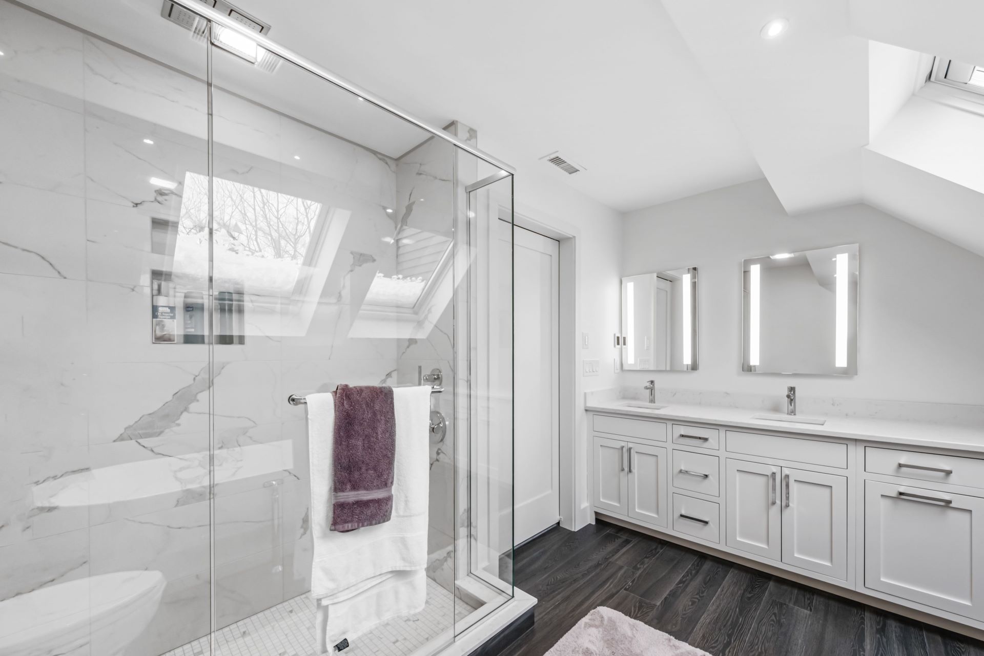 A bathroom with a walk in shower and two sinks.