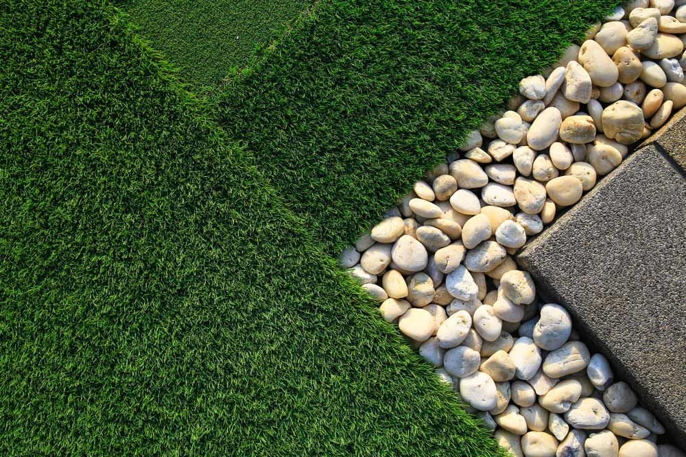 Green Turf, White Pebbles, And Gray Paving Stones Form A Diagonal Garden Design