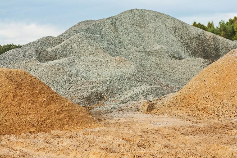 A Pile Of Dirt And Rocks In A Field With Trees In The Background — Ian Brown Sand Supplies and Tipper Hire In Port Macquarie, NSW
