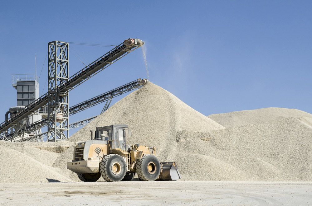A Bulldozer Is Loading Sand Into A Conveyor Belt — Ian Brown Sand Supplies and Tipper Hire In Port Macquarie, NSW