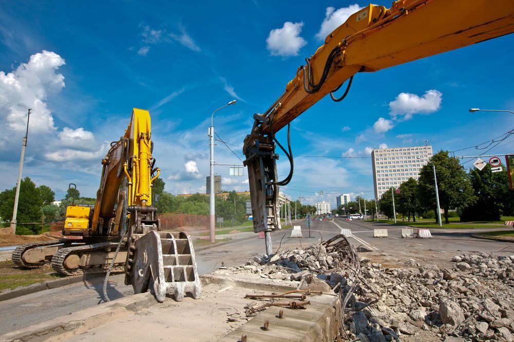 A Yellow Excavator Is Working On A Construction Site — Ian Brown Sand Supplies And Tipper Hire In Port Macquarie, NSW
