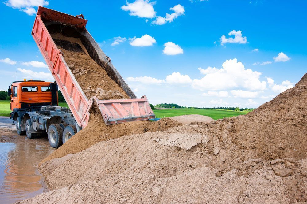 A Tipper Truck Tilts Its Bed to Unload Sand on the Port Macquarie