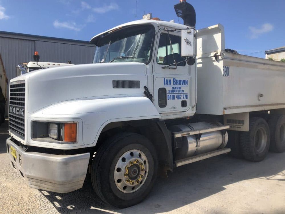 White Mack Dump Truck Parked Outside a Building on the Port Macquarie