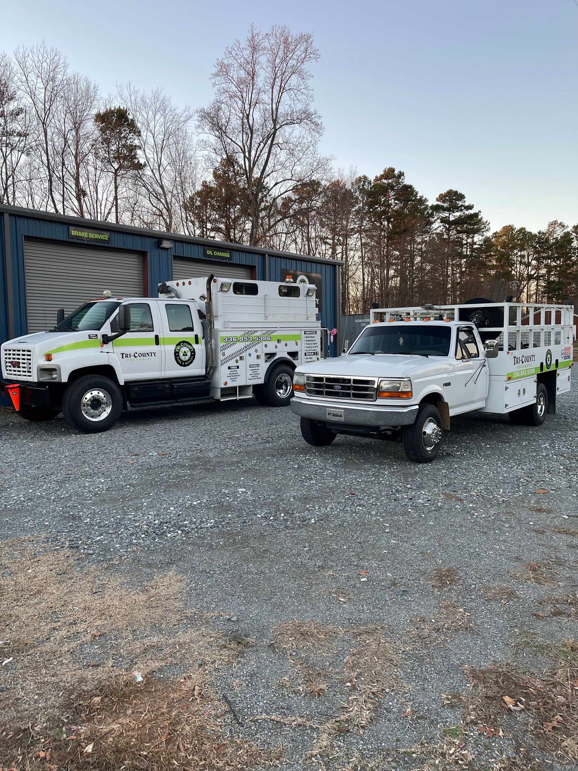 White work truck with a custom bed for landscaping or utility purposes parked outside.