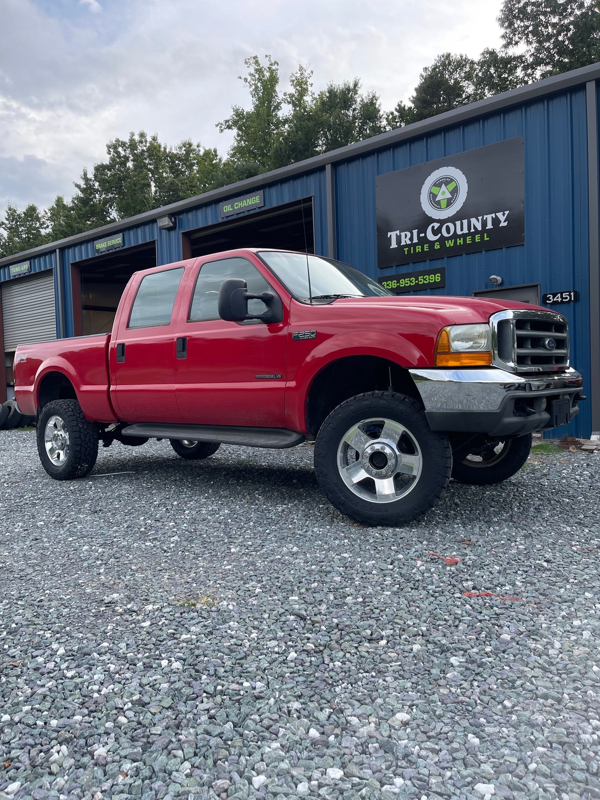Black suspension coil spring installed in a vehicle's wheel well.