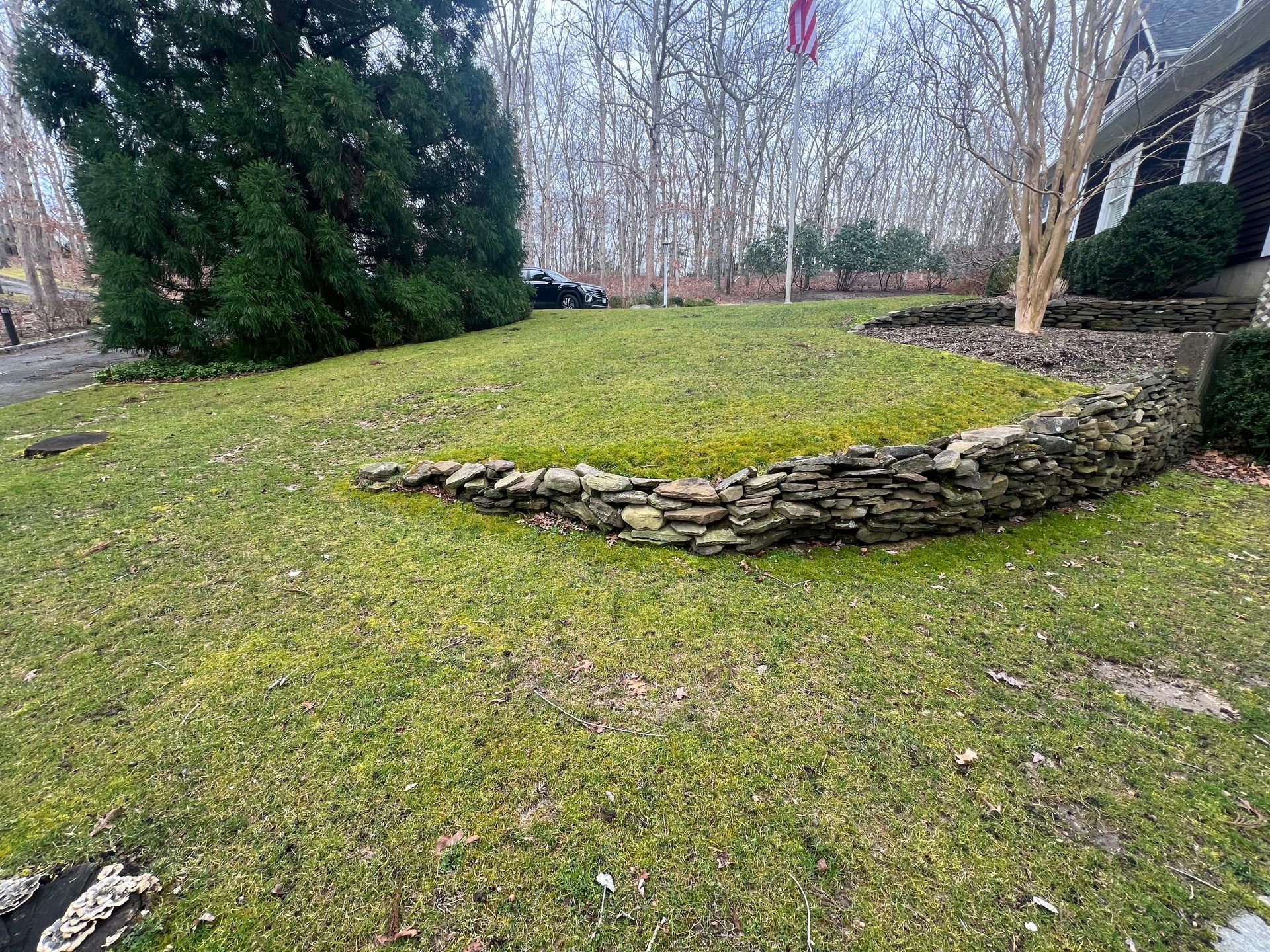 There is a stone wall in the middle of the lawn.