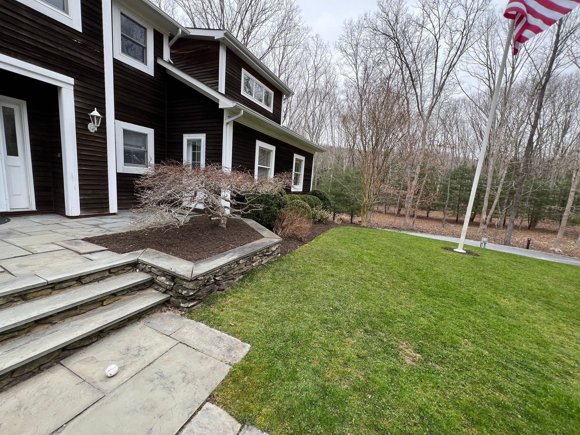 A large house with a flag pole in front of it.