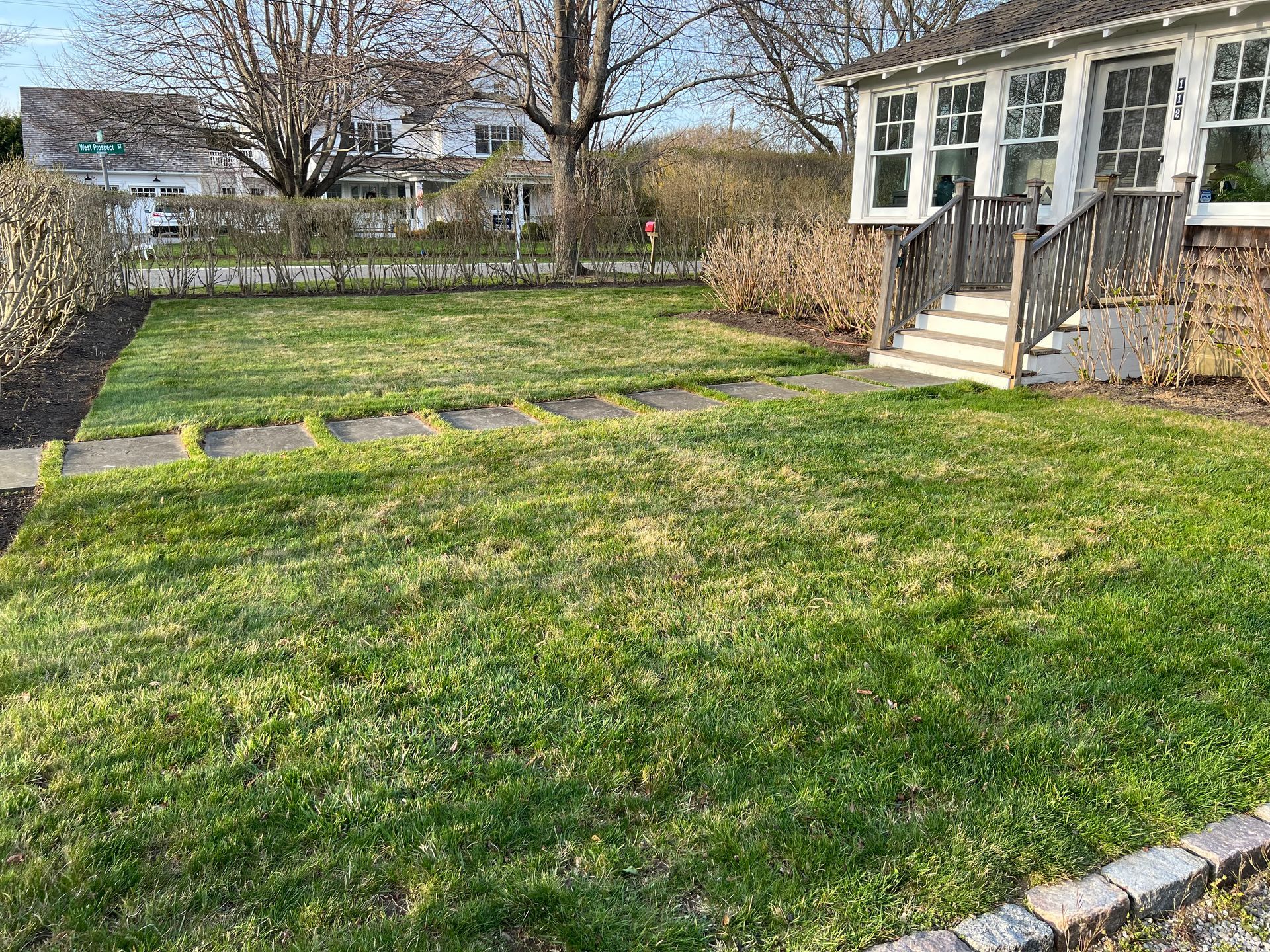 A house with a lush green lawn in front of it.