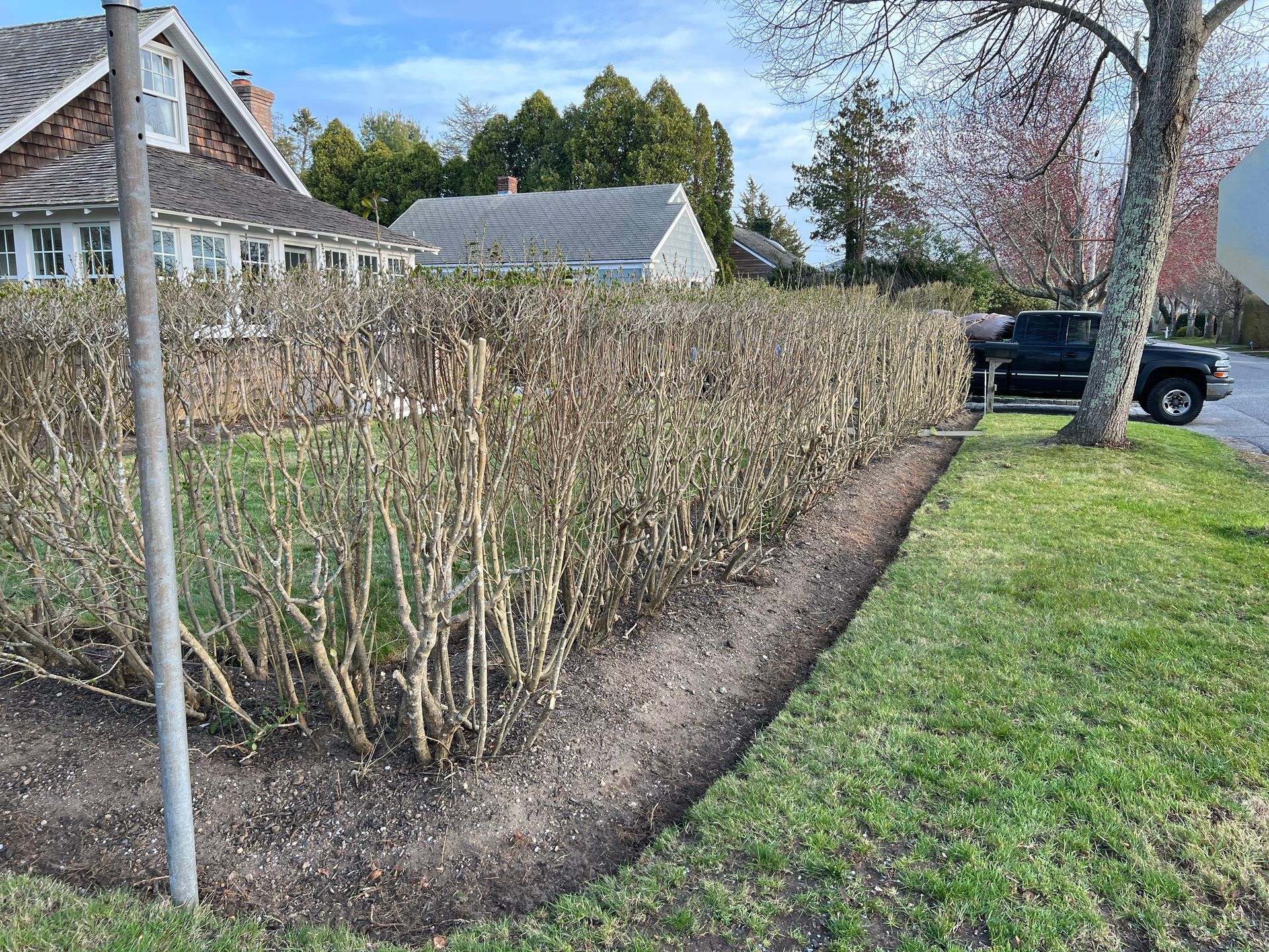 A truck is parked on the side of the road in front of a house.
