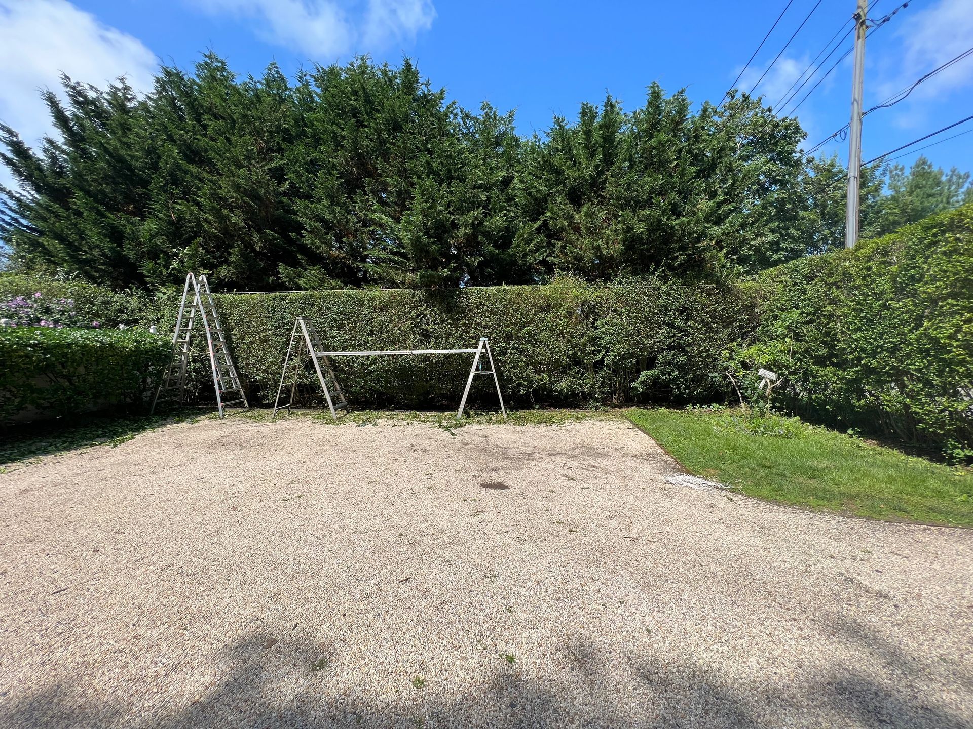 A gravel driveway with a swing in the middle of it