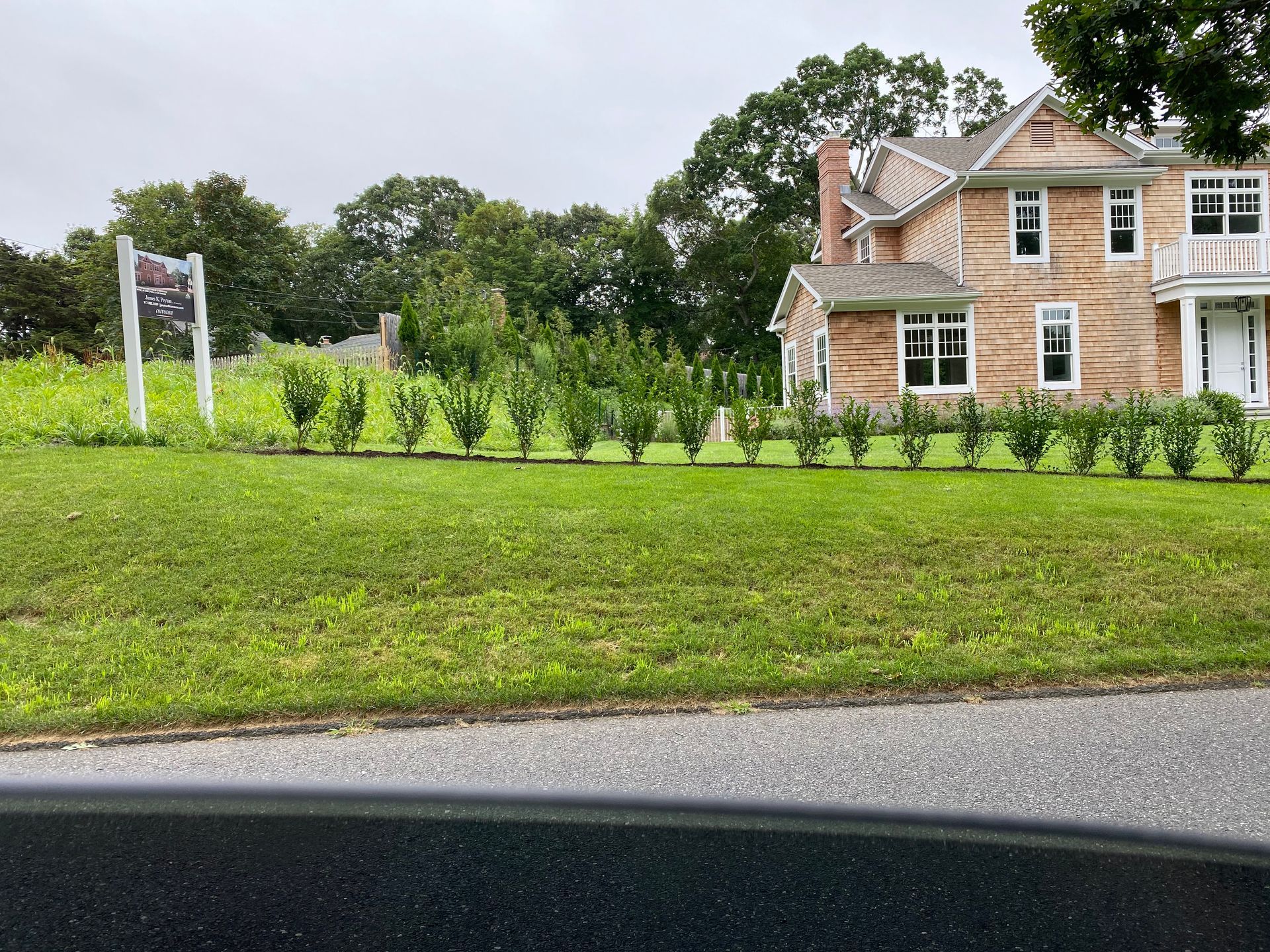 A large house sits in the middle of a lush green field