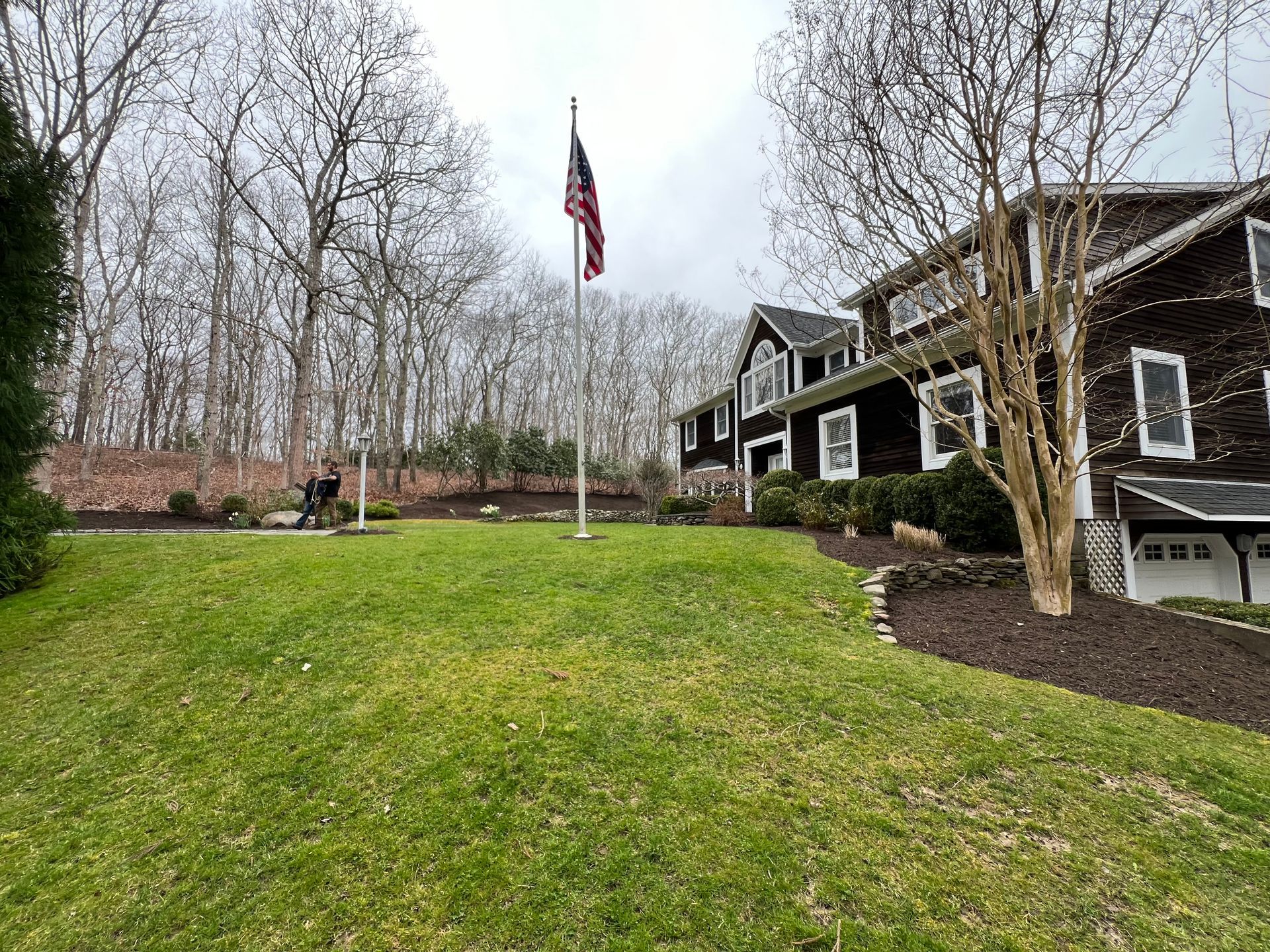 A large house with a flag pole in front of it.