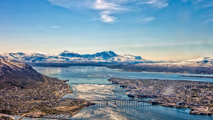 An aerial view of Tromsø city surrounded by water and mountains
