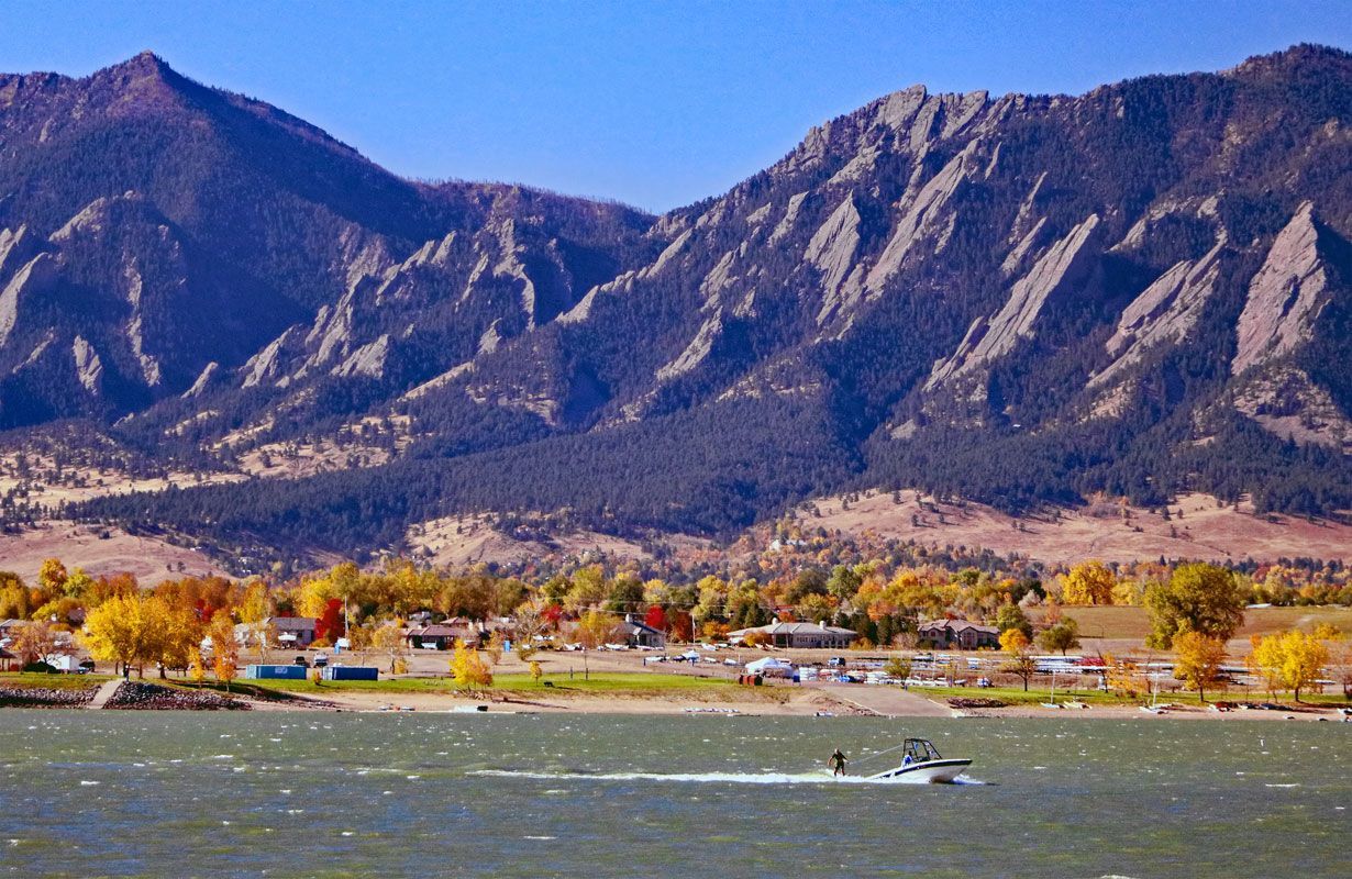 A boat is floating on a lake with mountains in the background.