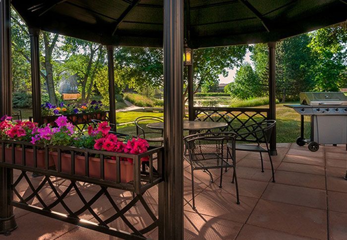 There is a gazebo with tables and chairs and a grill.