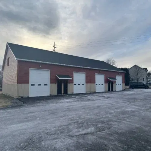 A row of garage doors are lined up in a parking lot.