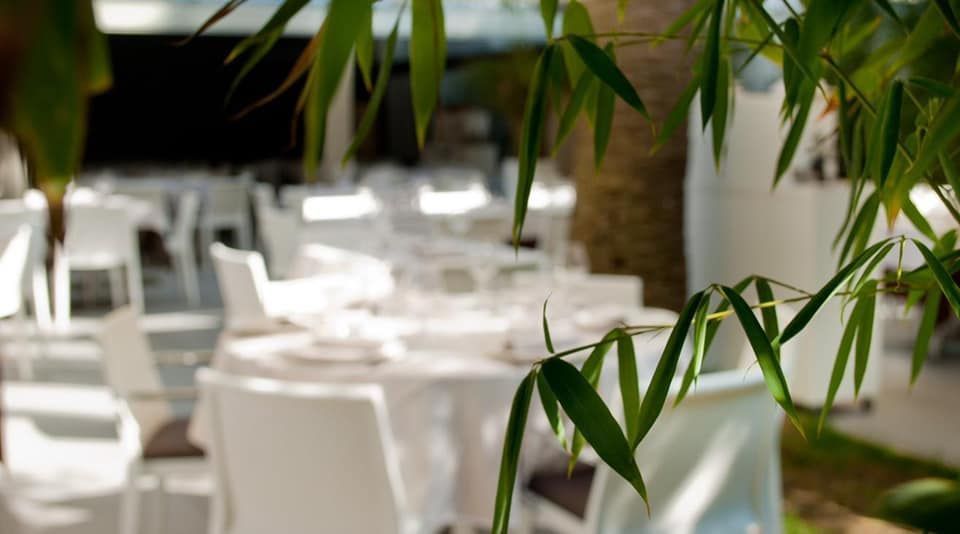 Un'immagine sfocata di un ristorante con tavoli e sedie bianchi.