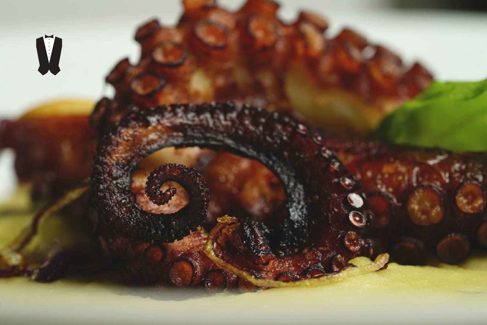 Un primo piano di un piatto di cibo con sopra un polipo.