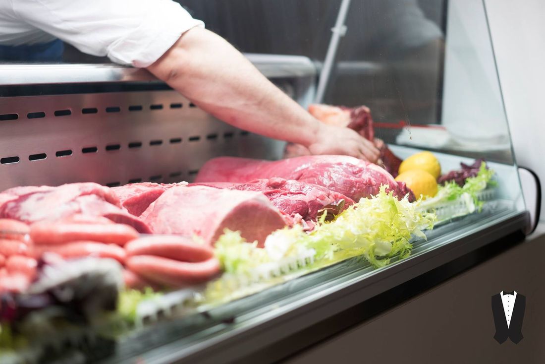 Una persona prende un pezzo di carne dal frigorifero.