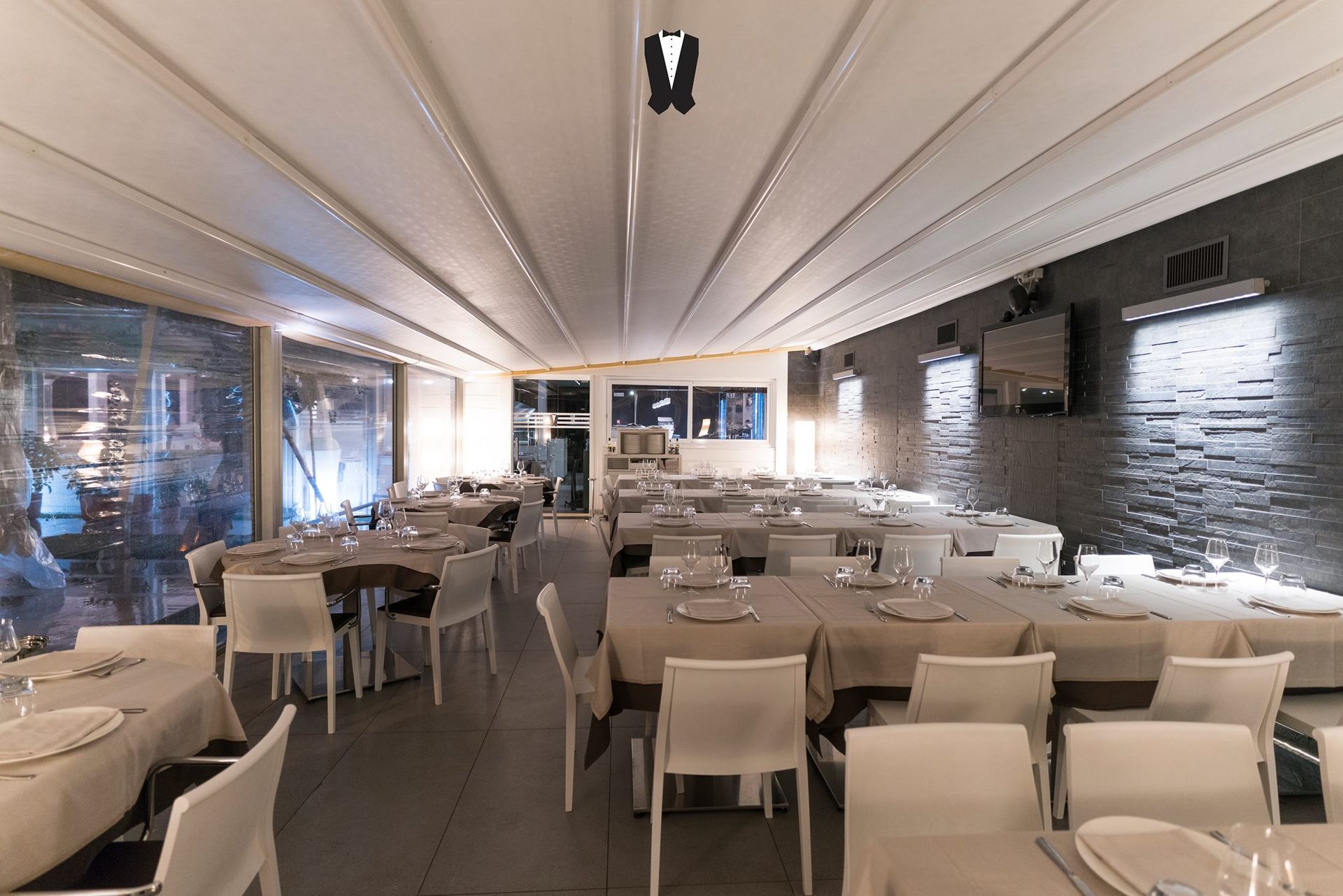 Una grande stanza con tavoli e sedie in un ristorante