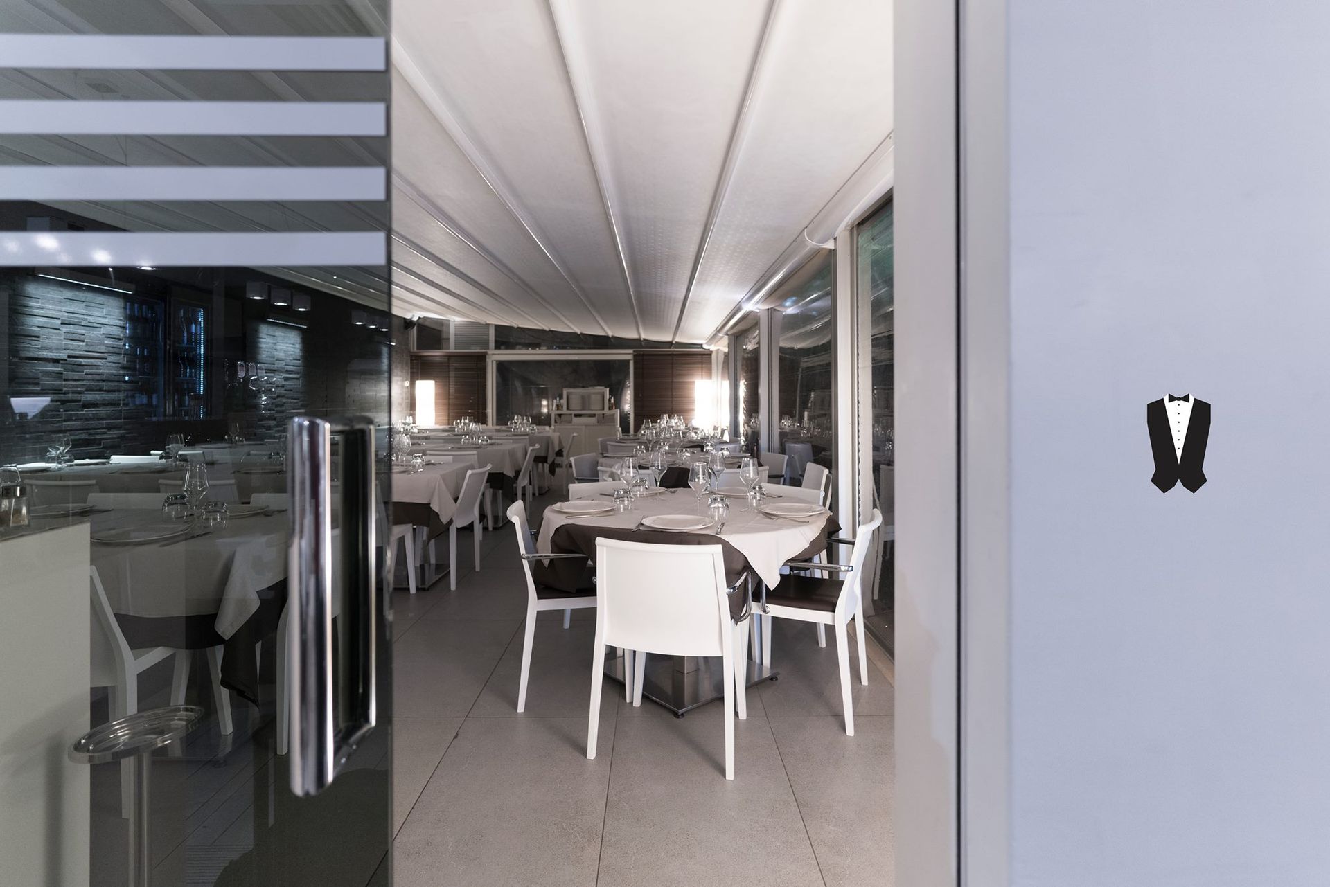 Un ristorante con tavoli e sedie e un cartello con su scritto