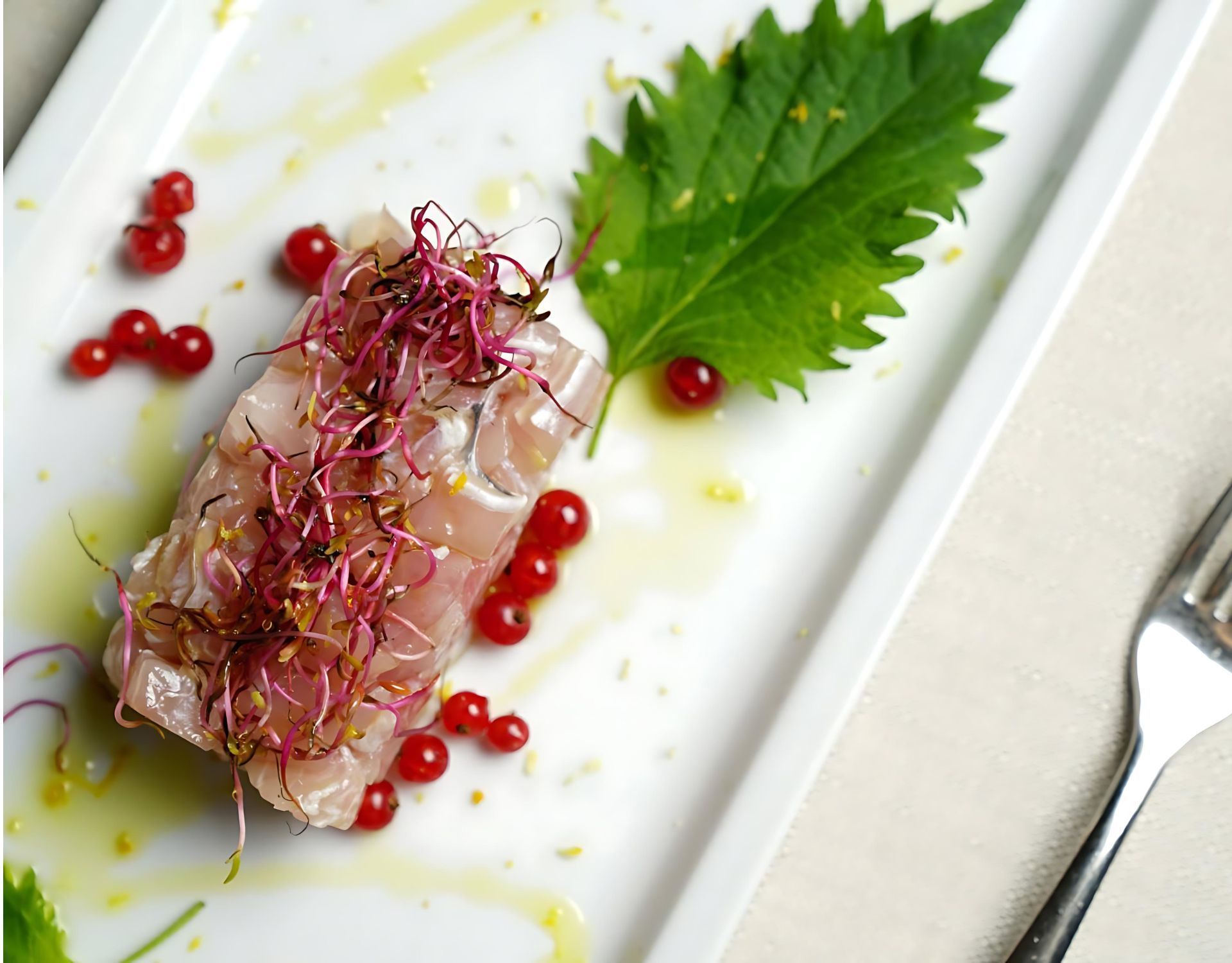 Un piatto di cibo con una foglia verde e bacche rosse