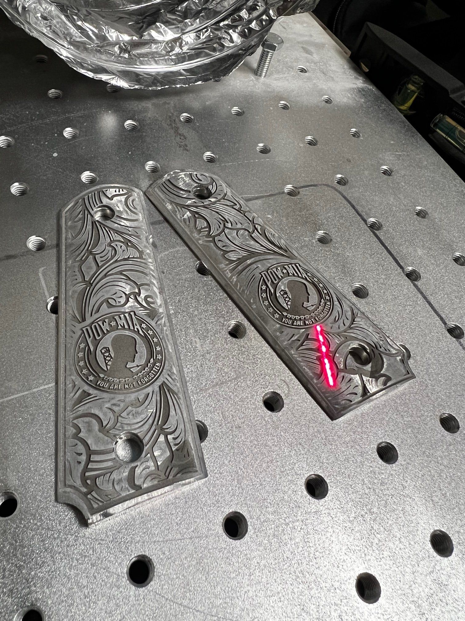 Two pieces of metal are sitting on top of a metal table.