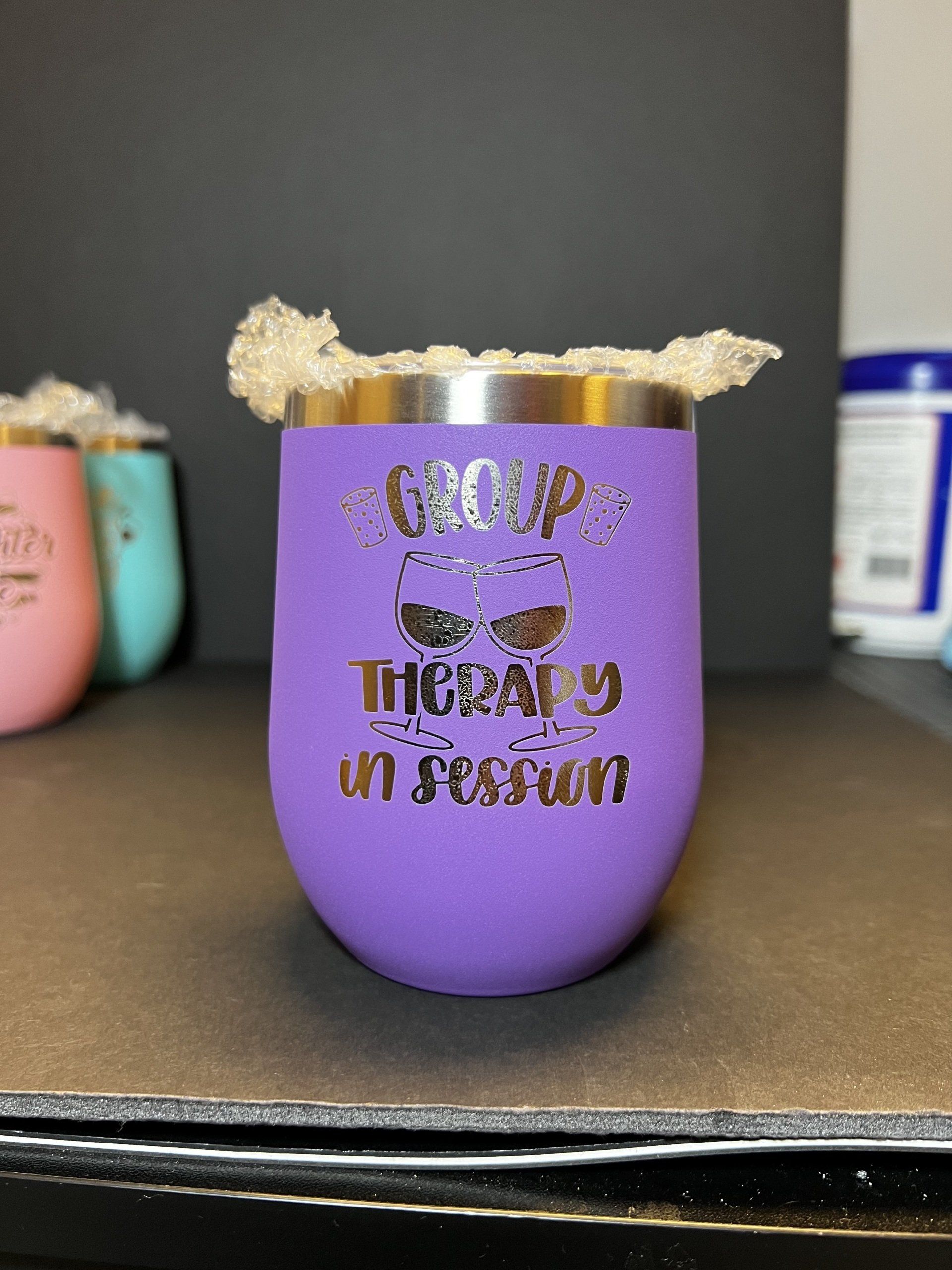 A purple wine glass that says group therapy in session