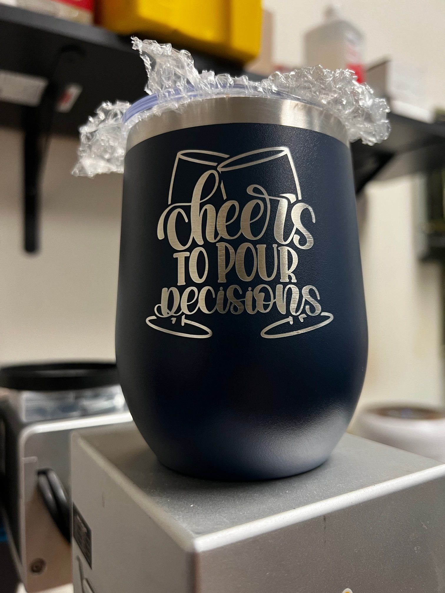 A stainless steel wine tumbler with the words `` cheers to pour decisions '' written on it.