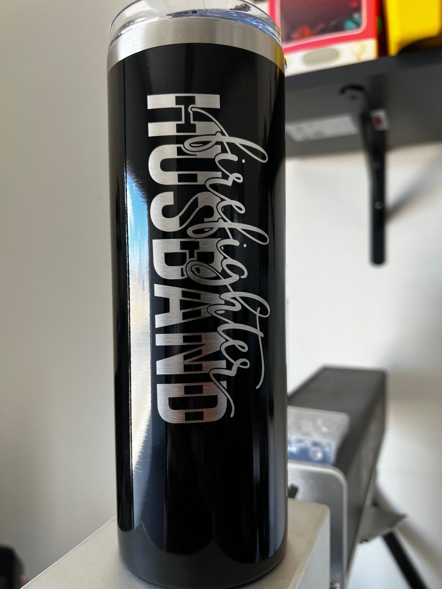 A black stainless steel tumbler with the words `` husband '' written on it.