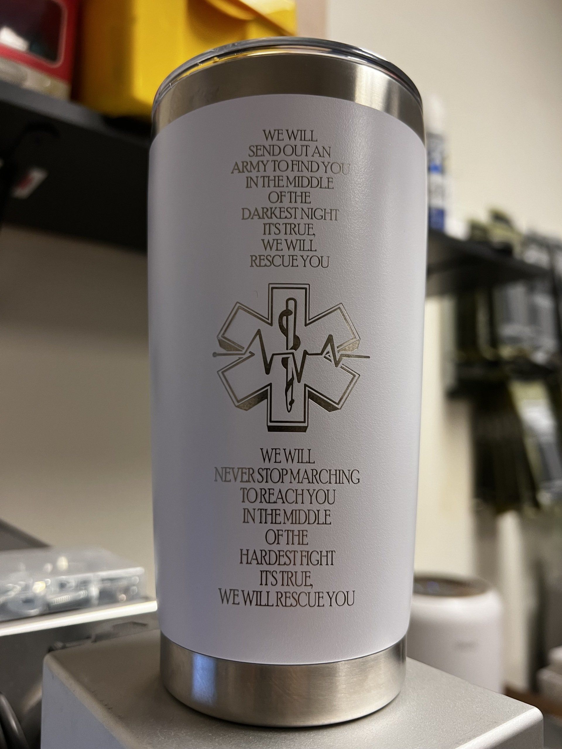 A stainless steel tumbler with a medical symbol on it.