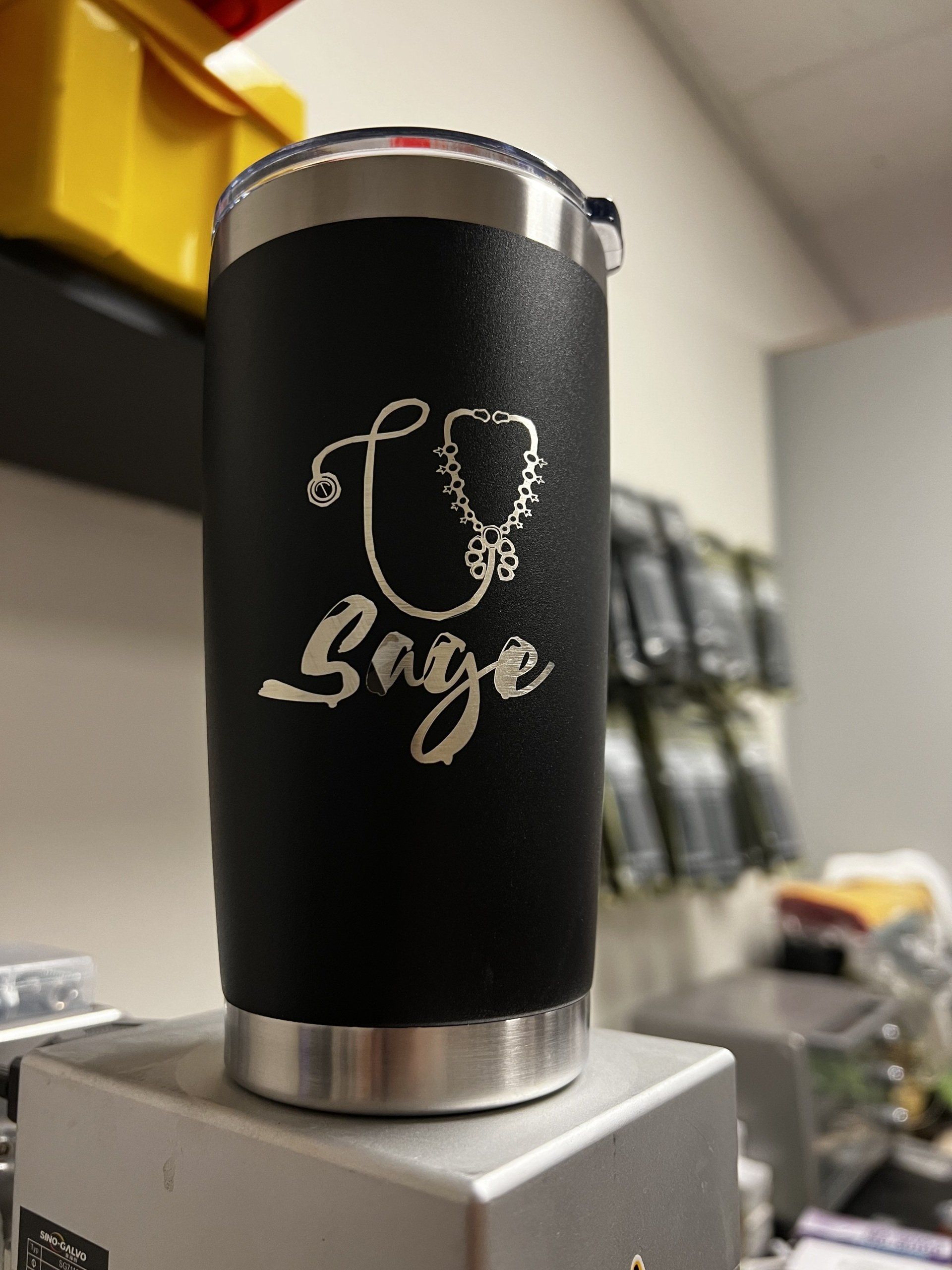 A black tumbler with a stethoscope and the word sage on it